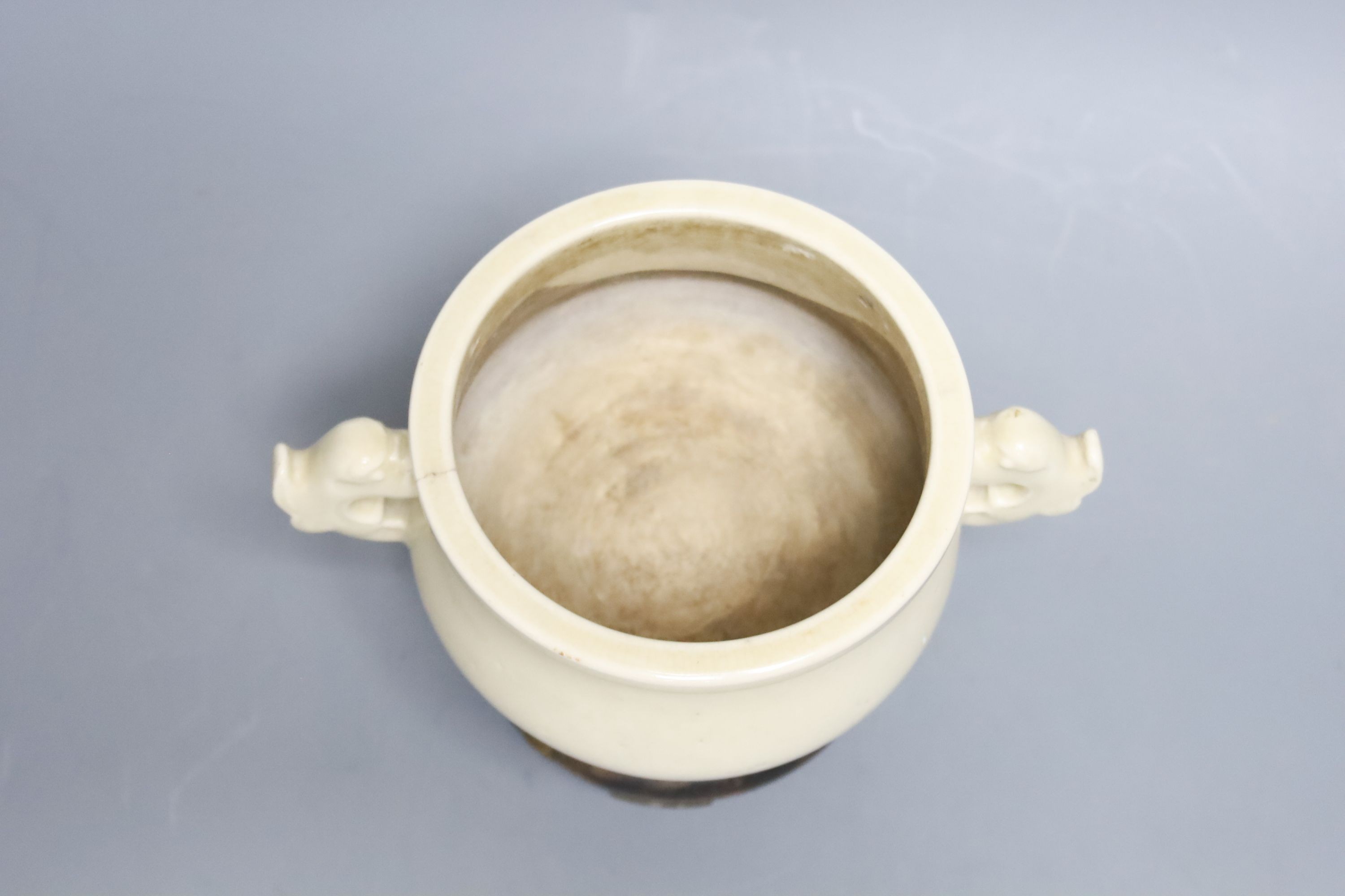 A Chinese cream crackle glazed censer, Qing dynasty, with dragon handles, 19 cm wide, on hardwood stand, W 18cm